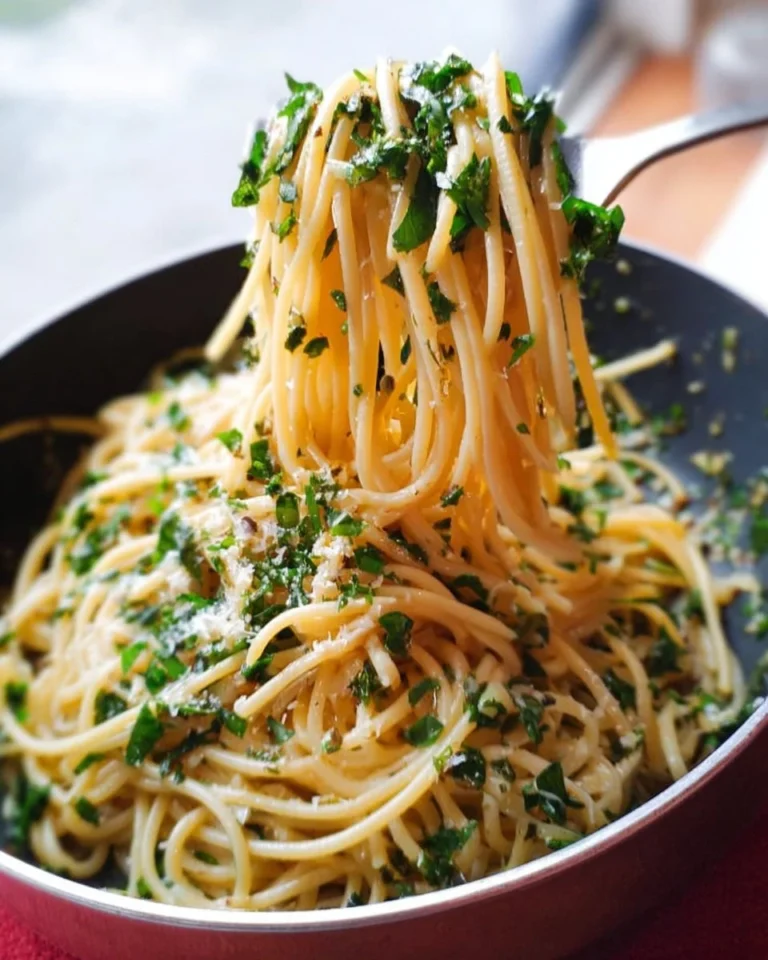 Knoblauch-Butter-Spaghetti mit frischen Kräutern auf einem Teller.