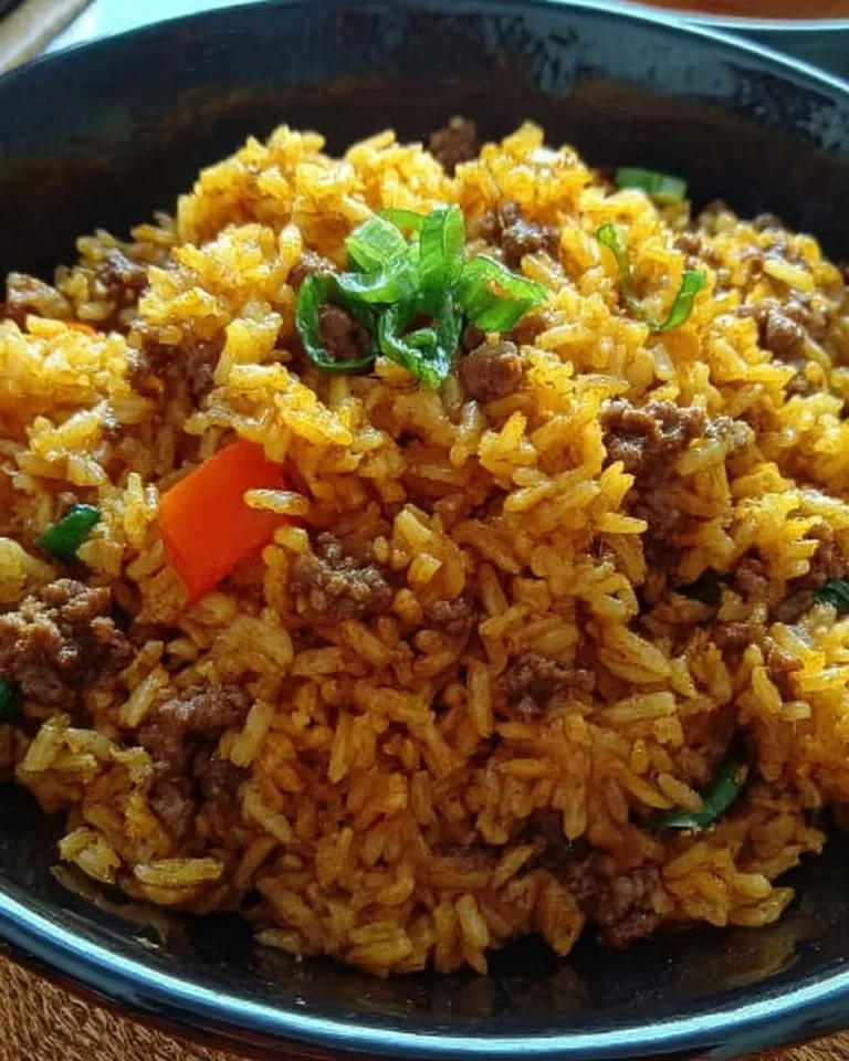 Schneller Curryreis mit Hackfleisch auf einem Teller serviert.