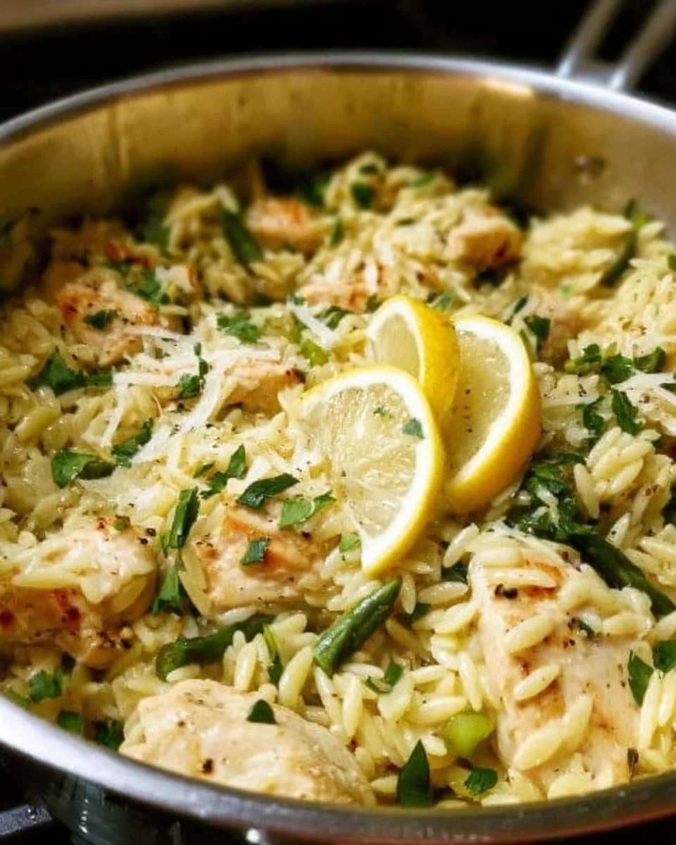 Zitronen-Hühnchen Orzo in einem Topf mit frischen Kräutern und Zitrone