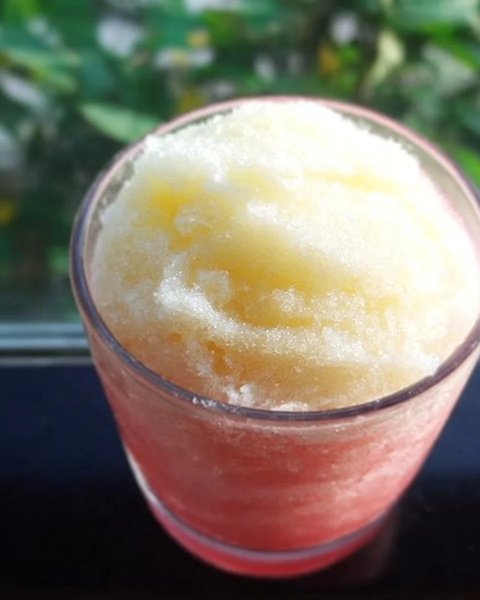 Hawaiianer Slush in einem bunten Becher mit Eis und Früchten.