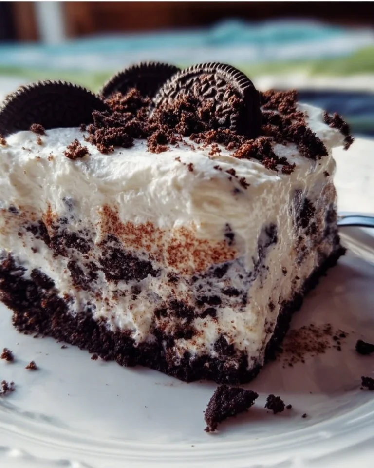 Oreo Poke Kuchen mit Schokoladensauce und Oreokeksen auf einem Teller