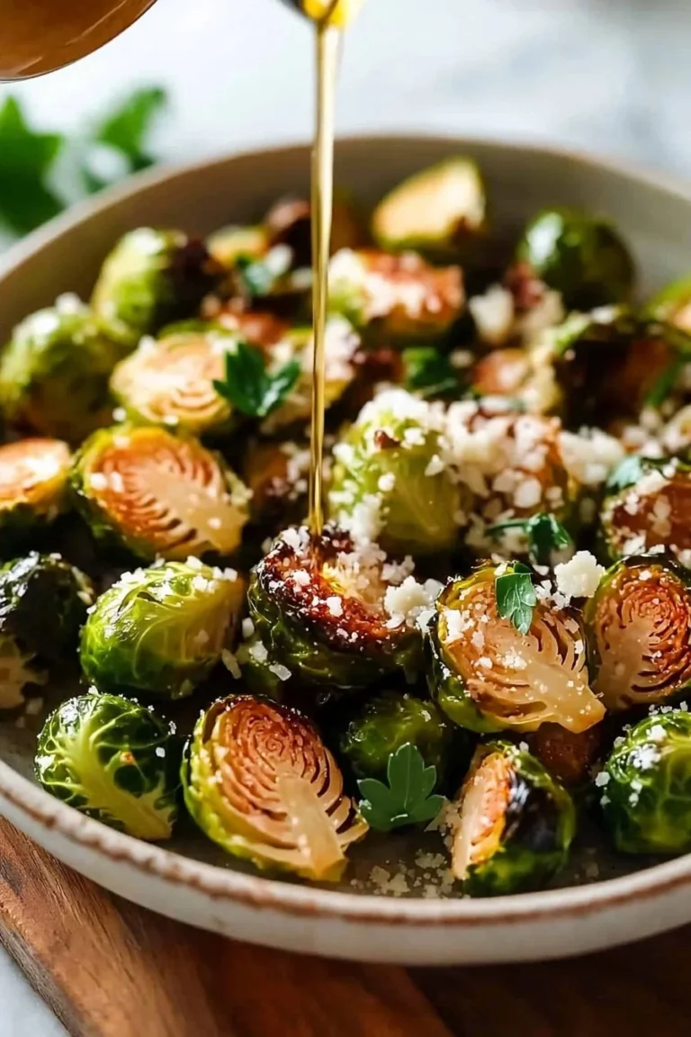 Knoblauch-Parmesan-gerösteter Rosenkohl auf einem Teller, serviert mit frischen Kräutern.