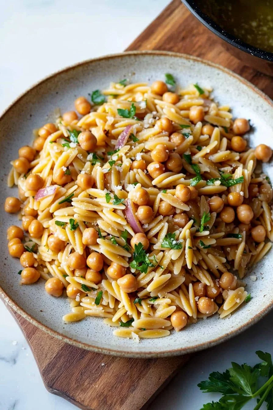 Orzo-Pasta mit Kichererbsen in einer bunten Schüssel serviert