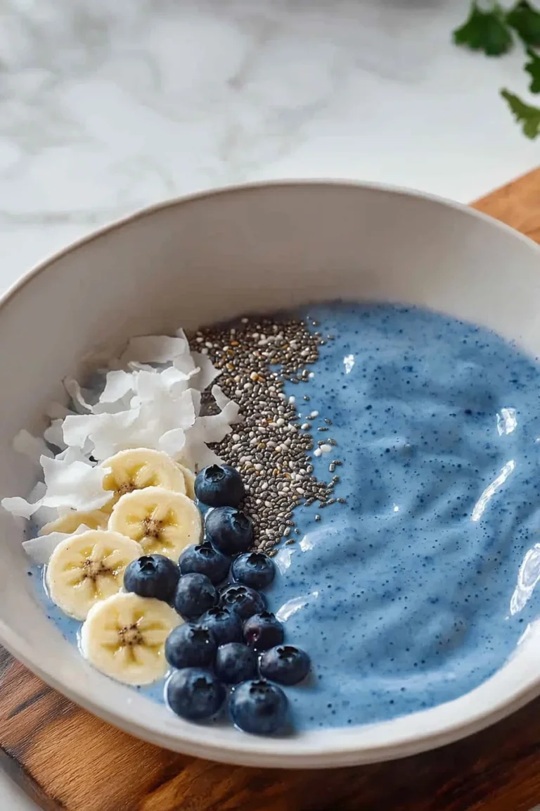 Blaue Smoothie-Schüssel mit frischen Zutaten und buntem Obst