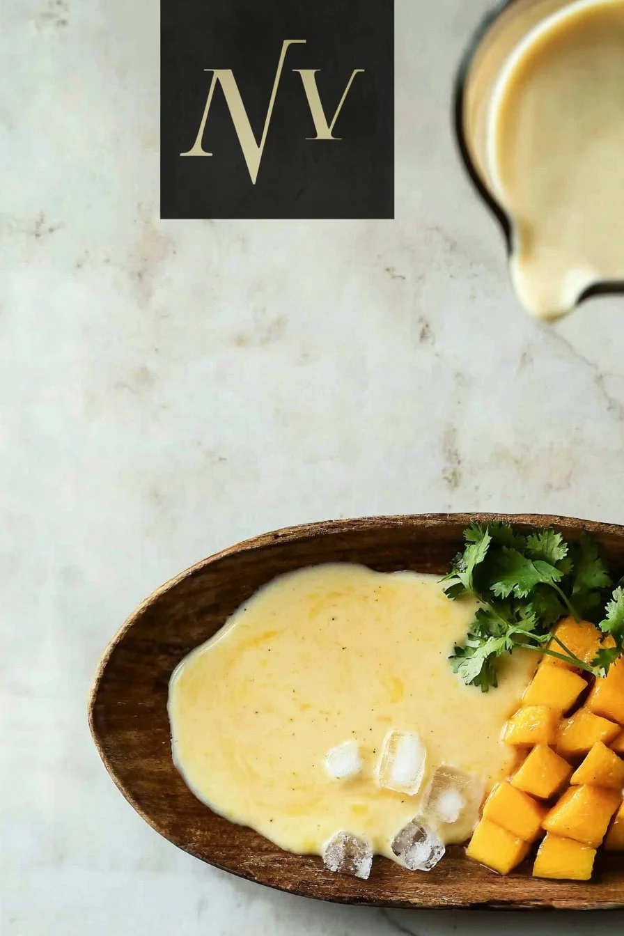 Ein Glas Mango Lassi, cremig und erfrischend, serviert mit einer Mango-Dekoration.